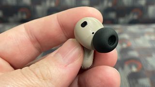 JBL Tour Pro 3 noise cancelling earbuds on earbud held in hand